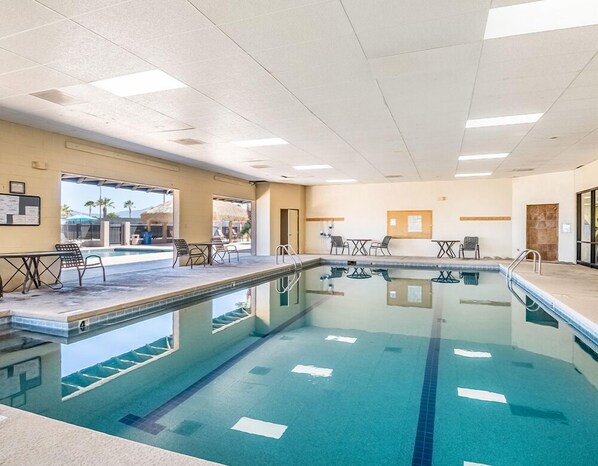 An indoor swimming pool with clear lanes, a sunroof, and a view of the outside.