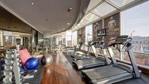 A gym with treadmills, exercise balls, and weight machines. - Donatello Hotel (Dubai)