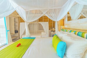 Una camera da letto con un letto, un tappeto verde, un comodino, uno specchio e una finestra con tende.