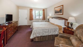 A hotel room with a bed, a TV, a desk, and a chair.