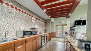 A modern kitchen with a tiled backsplash, stainless steel appliances, and wooden cabinets.