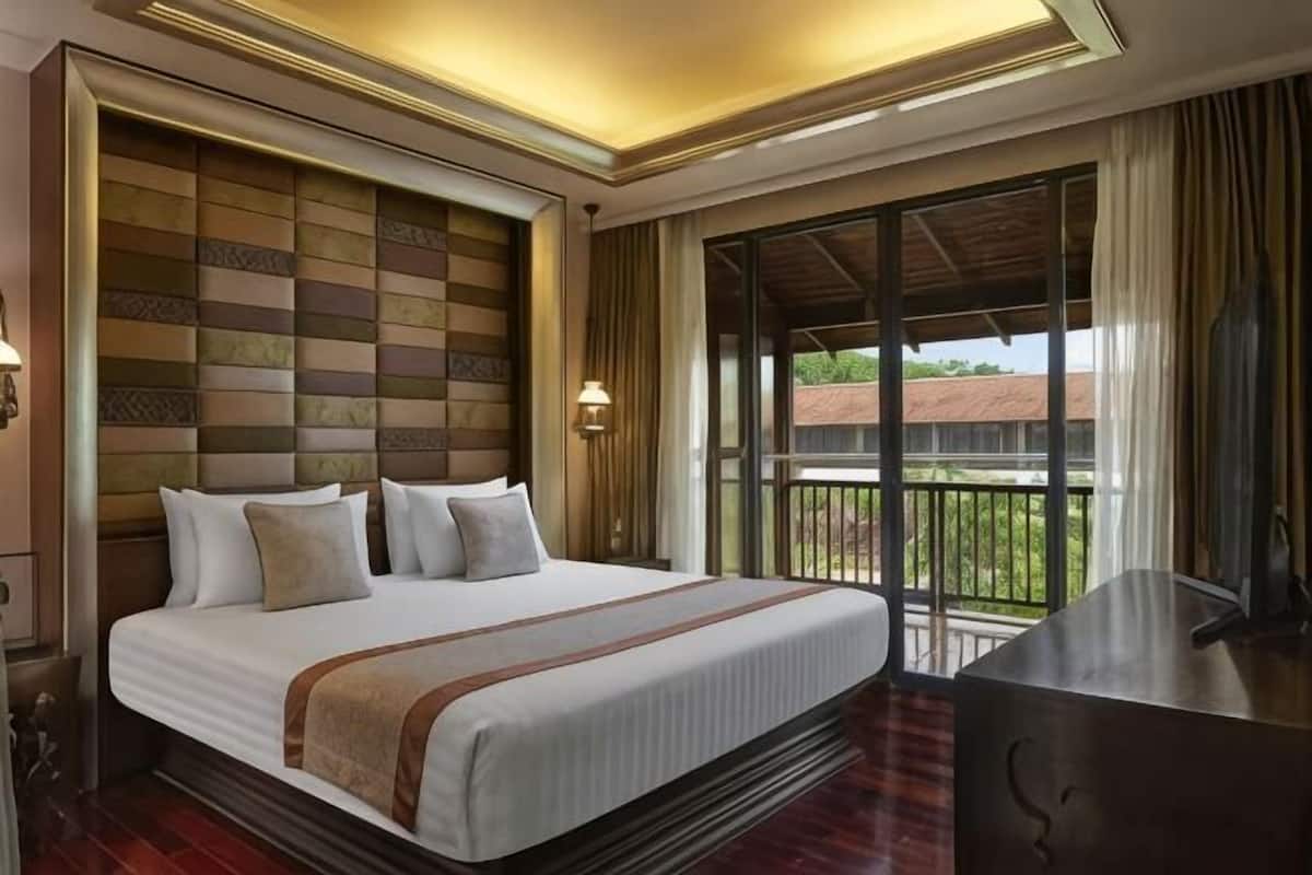 Habitación de hotel con una cama grande, un balcón con vistas y un diseño moderno.