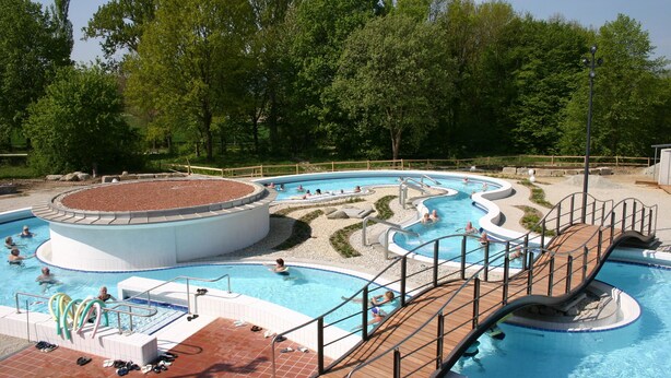 A swimming pool with multiple lanes and a wooden deck.
