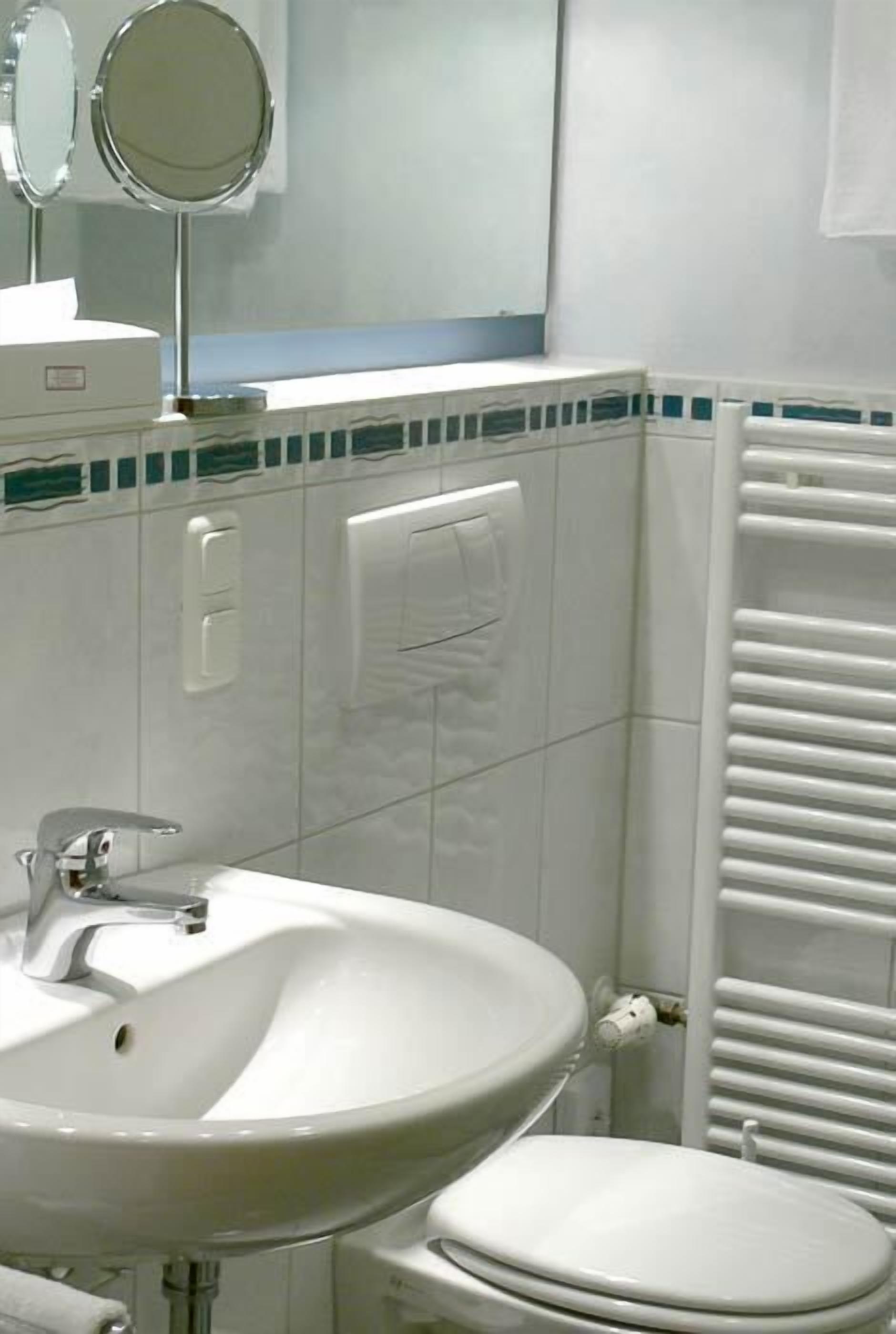 A bathroom with a sink, mirror, and toilet.