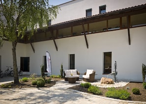 A courtyard with outdoor seating, bicycles, and a flag. - Hotel Chrysantihof (Bad Birnbach)