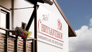 A hotel sign with the name 'Hotel Chrysantihof' and a logo.