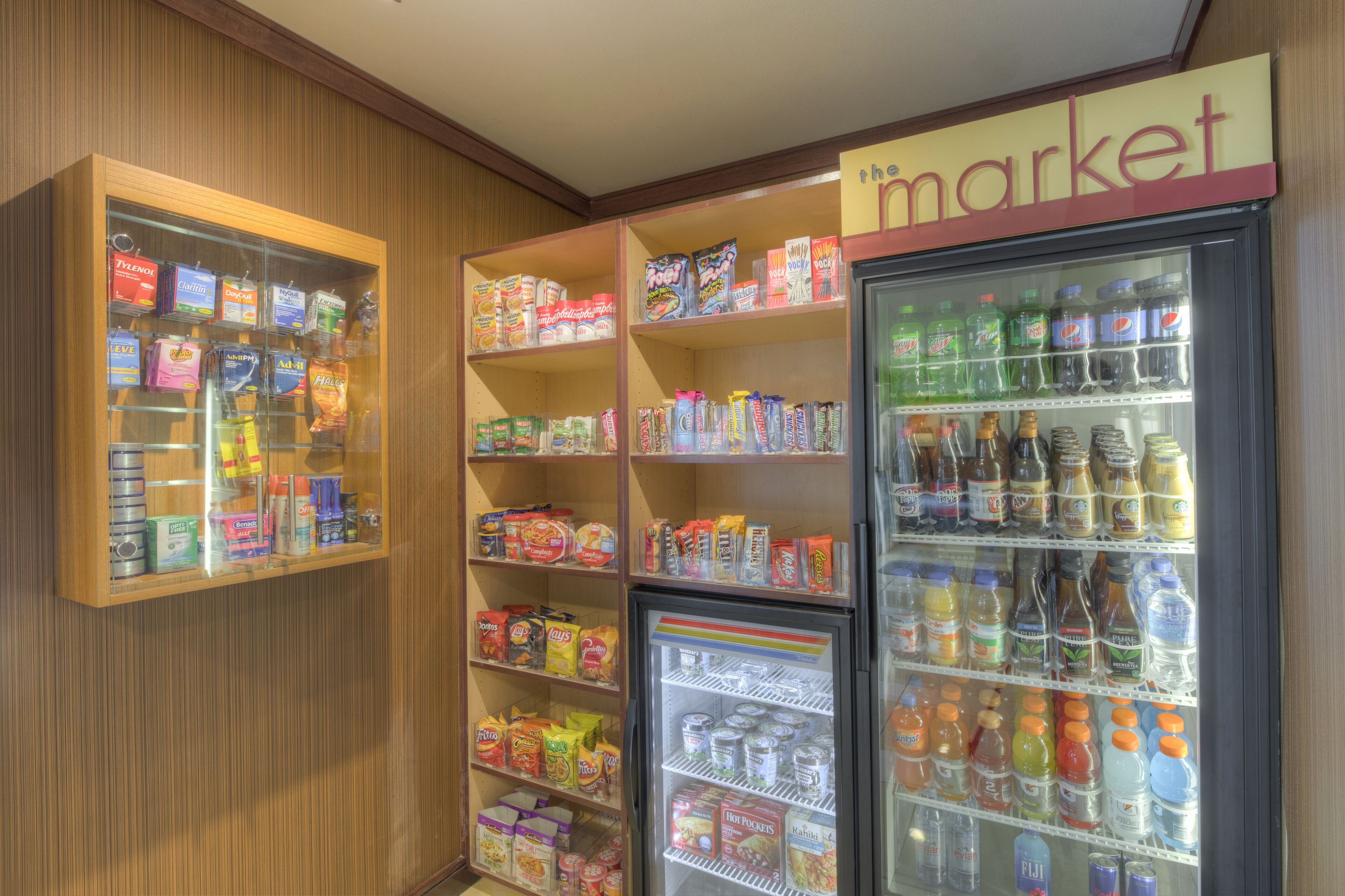 A grocery store interior with shelves stocked with snacks, beverages, and other food items.