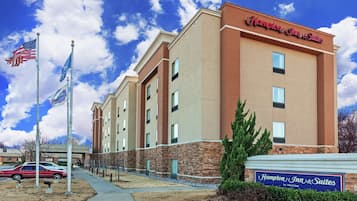 Hampton Inn & Suites features a modern exterior with a stone accent and multiple windows.