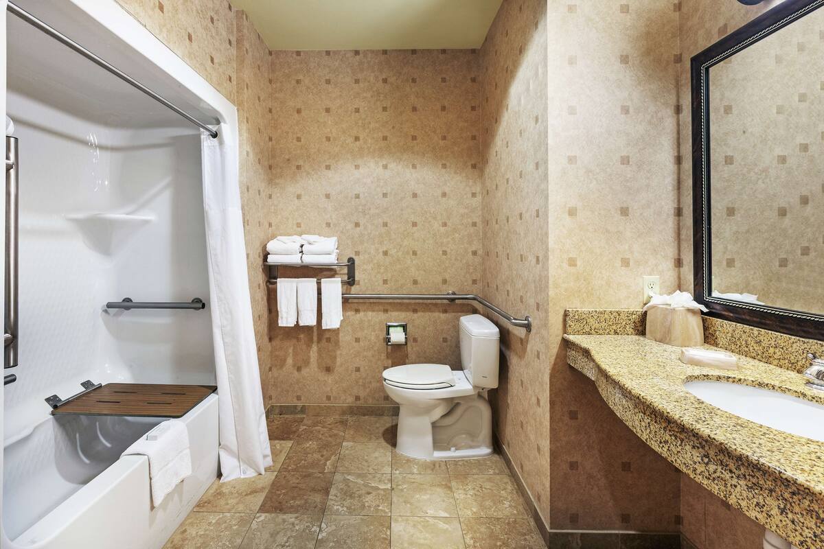 A bathroom with a bathtub, toilet, and sink.