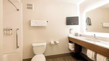 A modern bathroom with a toilet, sink, mirror, and shower.