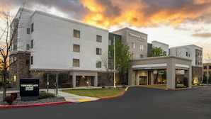 A hotel with a sign reading 'Towneplace Suites by Marriott,' a parking lot, and a building with a flat roof and large windows. - TownePlace Suites by Marriott Reno (Reno)
