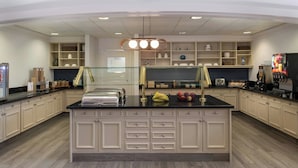 A modern kitchen with a central island, built-in cabinets, and a coffee machine. - TownePlace Suites by Marriott Reno (Reno)