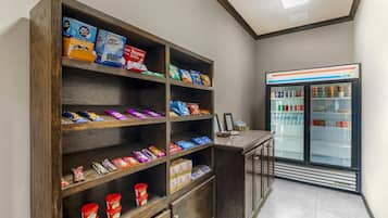 Uma estante com petiscos e alimentos embalados, e uma geladeira com bebidas.