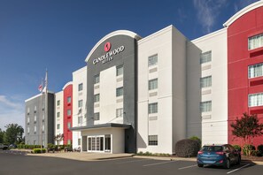 A hotel with a modern facade, a prominent sign for Candlewood Suites, and a parking lot with a blue car. - Candlewood Suites Nogales by IHG (Nogales)