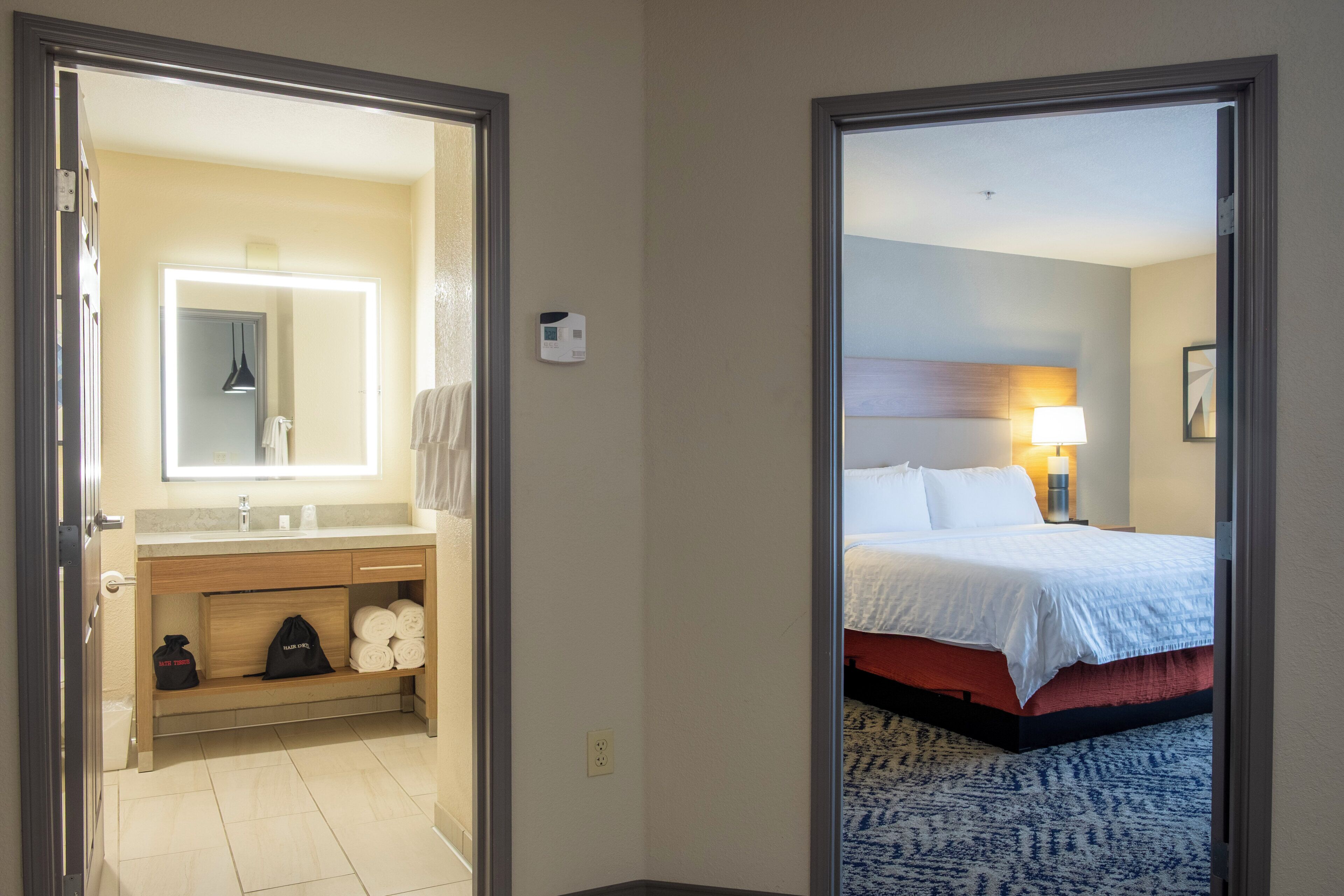 A hotel room with a bathroom and a bed.