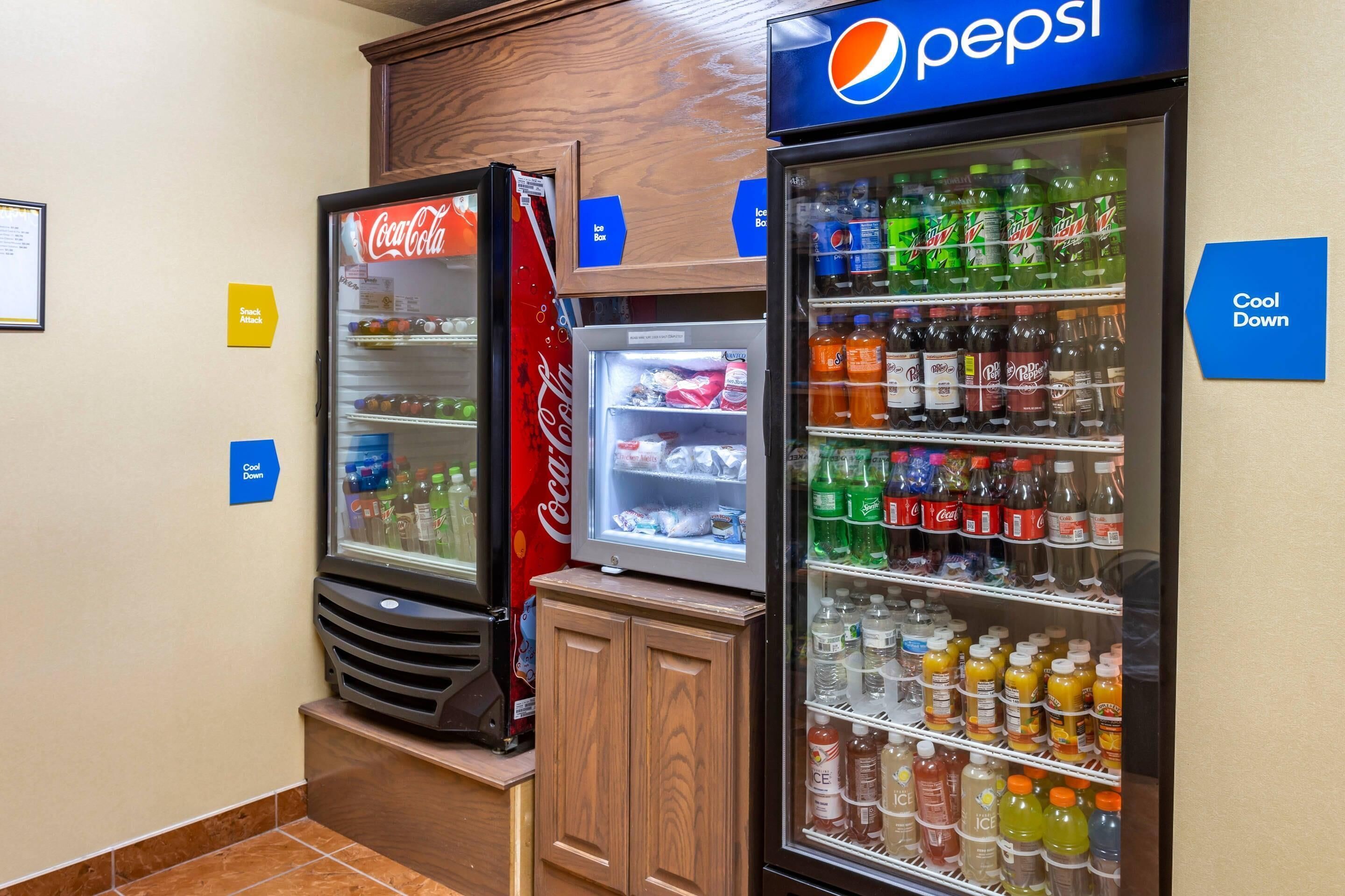 A vending area with Coca-Cola and Pepsi refrigerators, ice dispensers, and a sign indicating 'Cool Down' and 'Ice Box'.