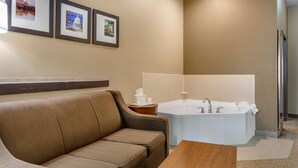 Un baño moderno con bañera, un sofá y cuadros en la pared.