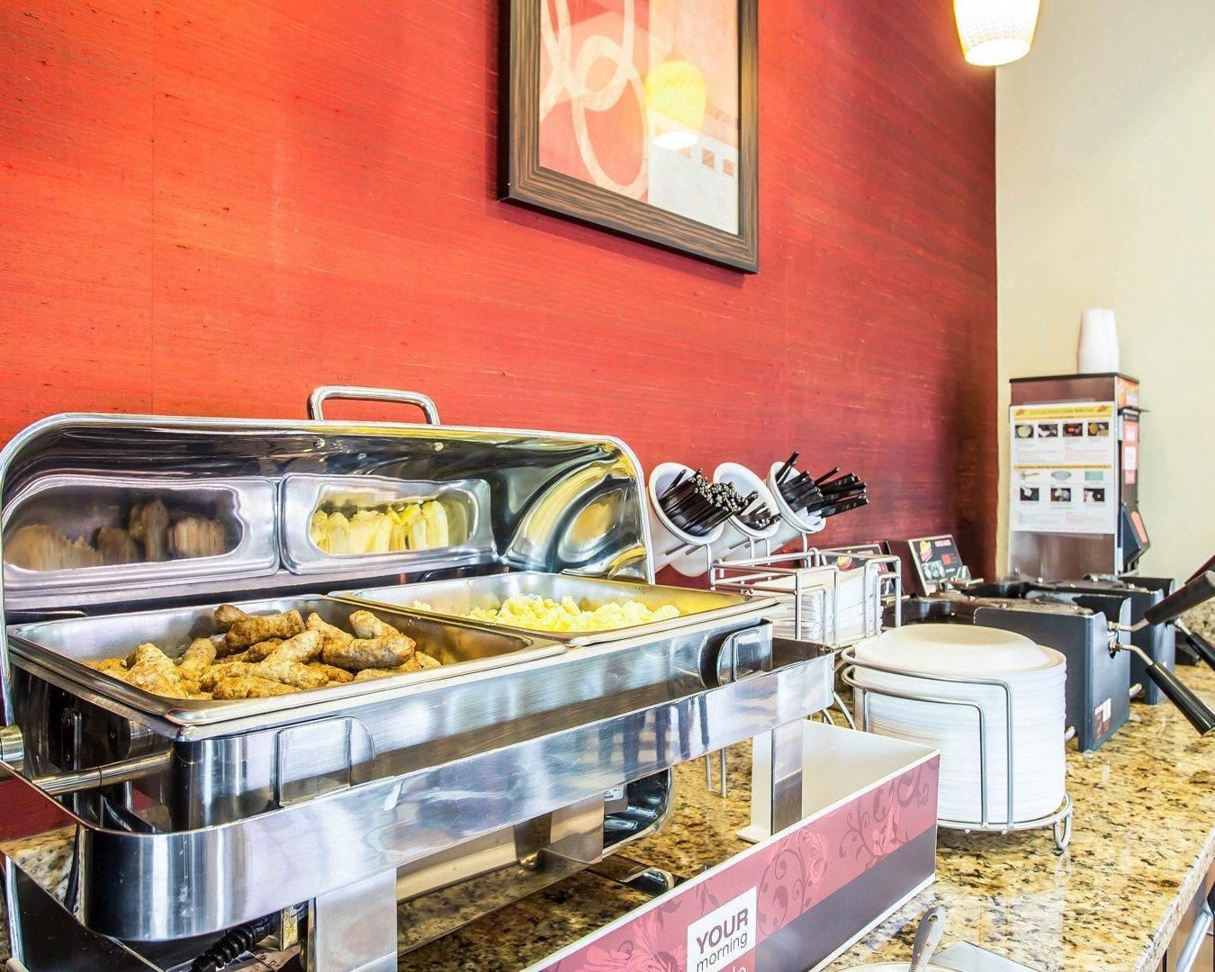 A buffet setup with various food items and utensils.