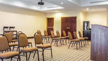 A conference room with rows of chairs, a podium, and a television.