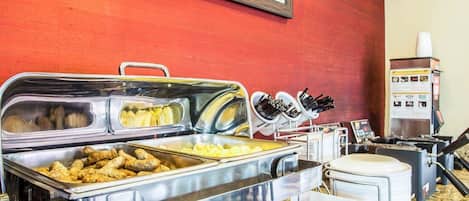 Una mesa de buffet con distintos alimentos y utensilios.
