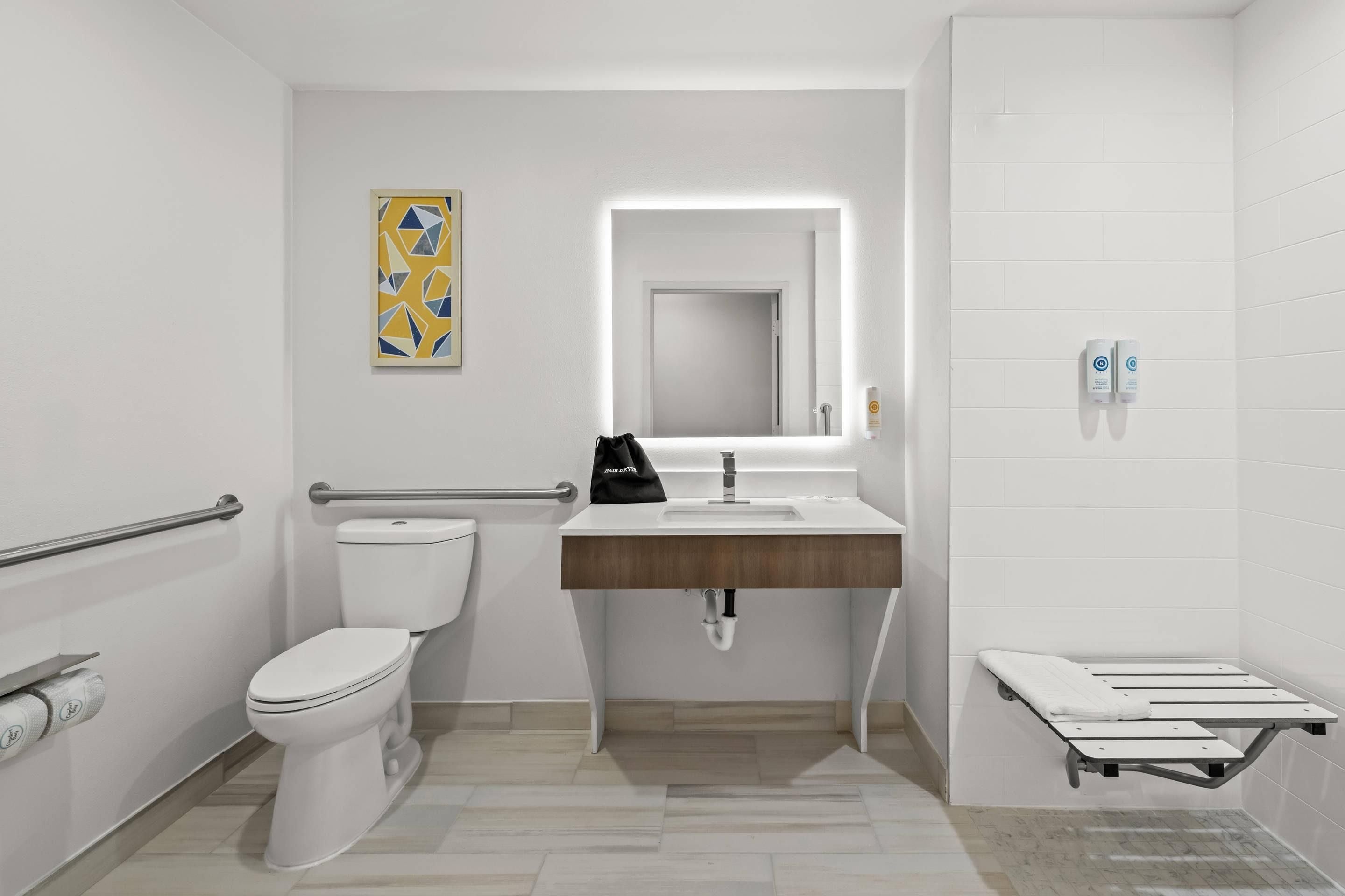 Un baño moderno con inodoro, lavamanos y zona de ducha.