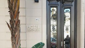 A hotel entrance with a dark wooden door, a sign reading "HOTEL COSTA RICA", and a number "4159". - Hotel Costa Rica (Buenos Aires)