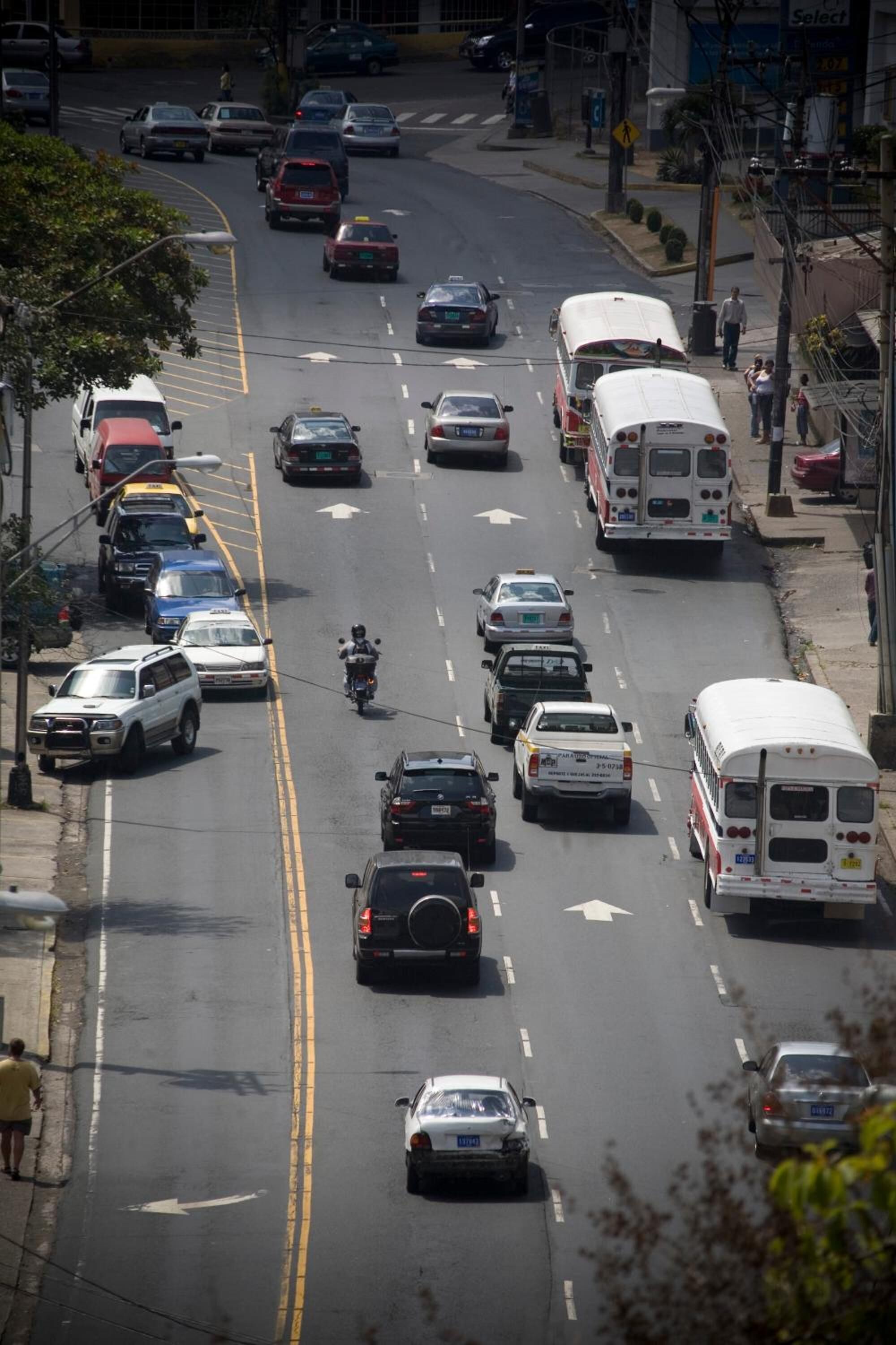 Una carretera con varios carriles y distintos vehículos, como automóviles, autobuses y motocicletas.