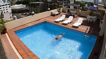 Alberca al aire libre y camastros