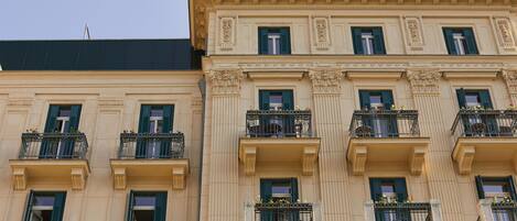 Un edificio de varios pisos con balcones, ventanas amplias y molduras decorativas.