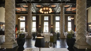A dining area with tables set for service, large decorative columns, and a chandelier. - Hotel Palace Portoroz Operated by Minor Hotels (Piran)