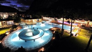 A large outdoor swimming pool with multiple circular sections and a surrounding deck area.