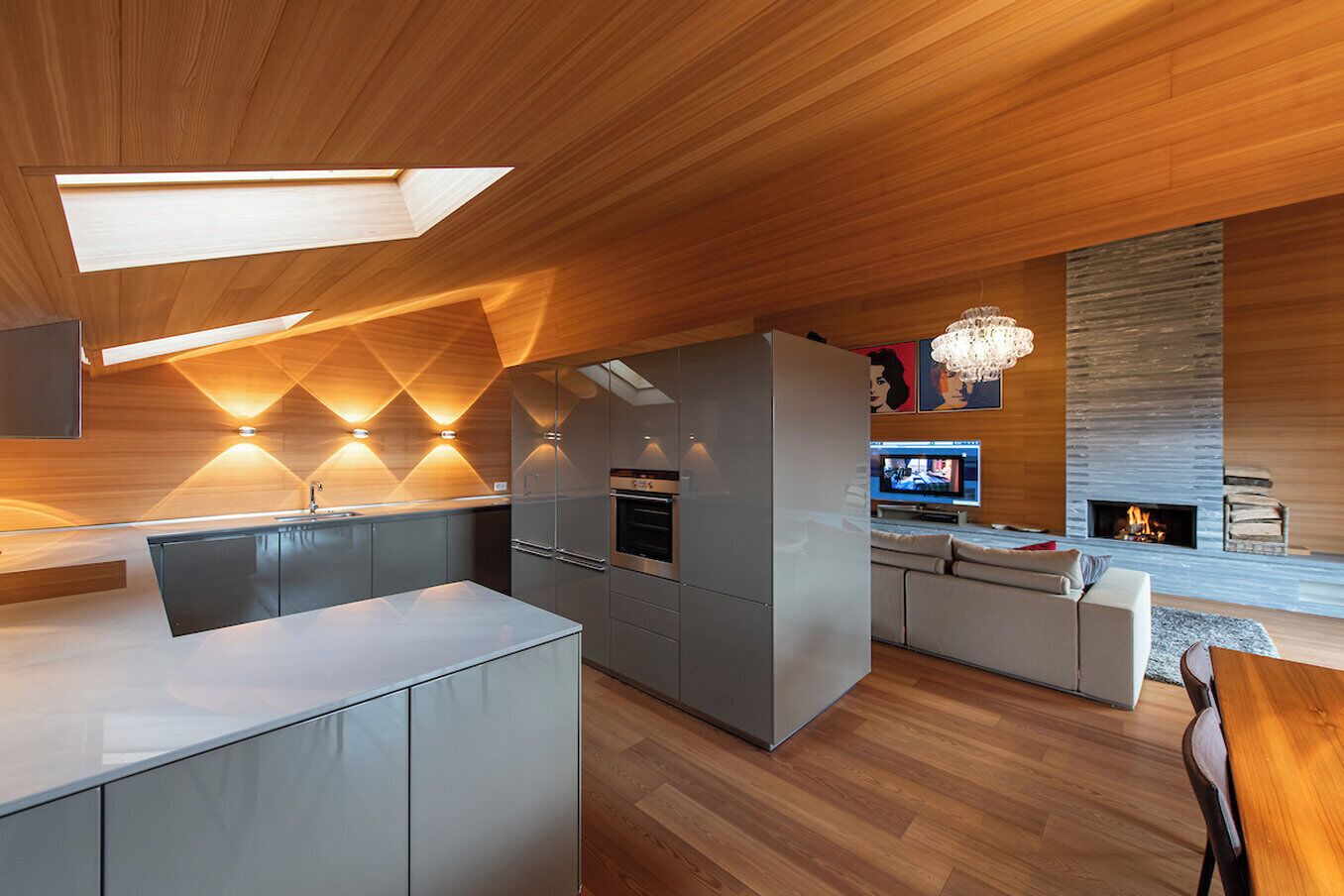 A modern kitchen with a central island, built-in appliances, and a dining area with a sofa and table.