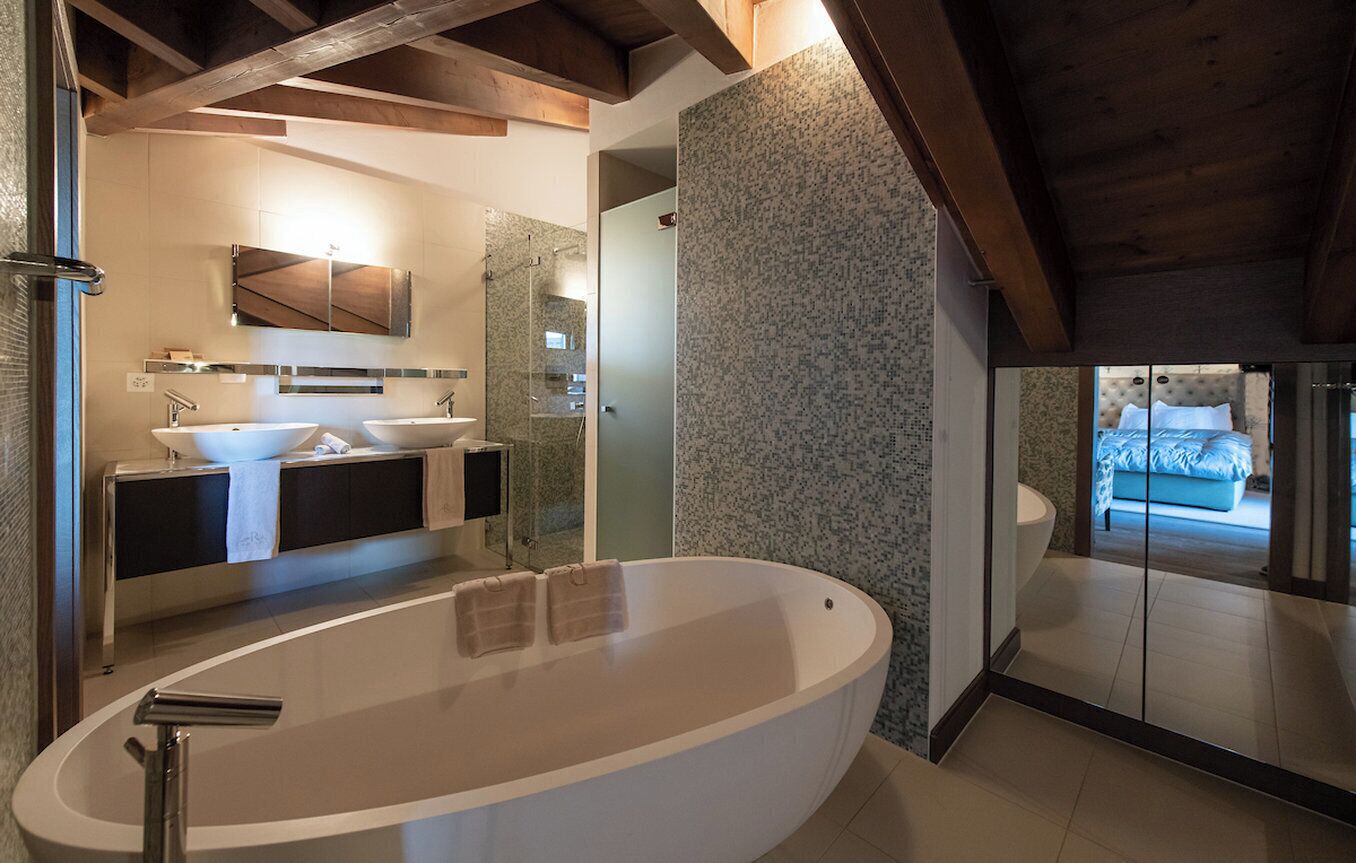 Une salle de bain moderne avec une baignoire sur pieds, un meuble-lavabo à deux vasques et un grand miroir.