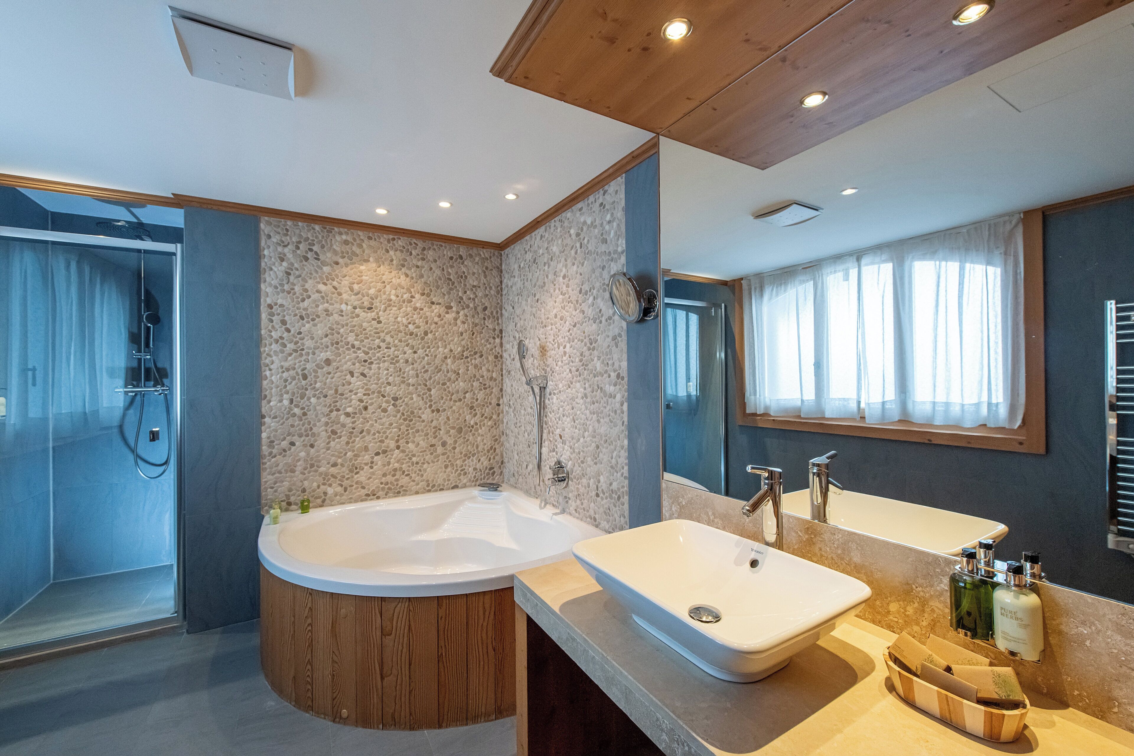 Un baño moderno con una bañera independiente, un lavabo grande y una zona de ducha.