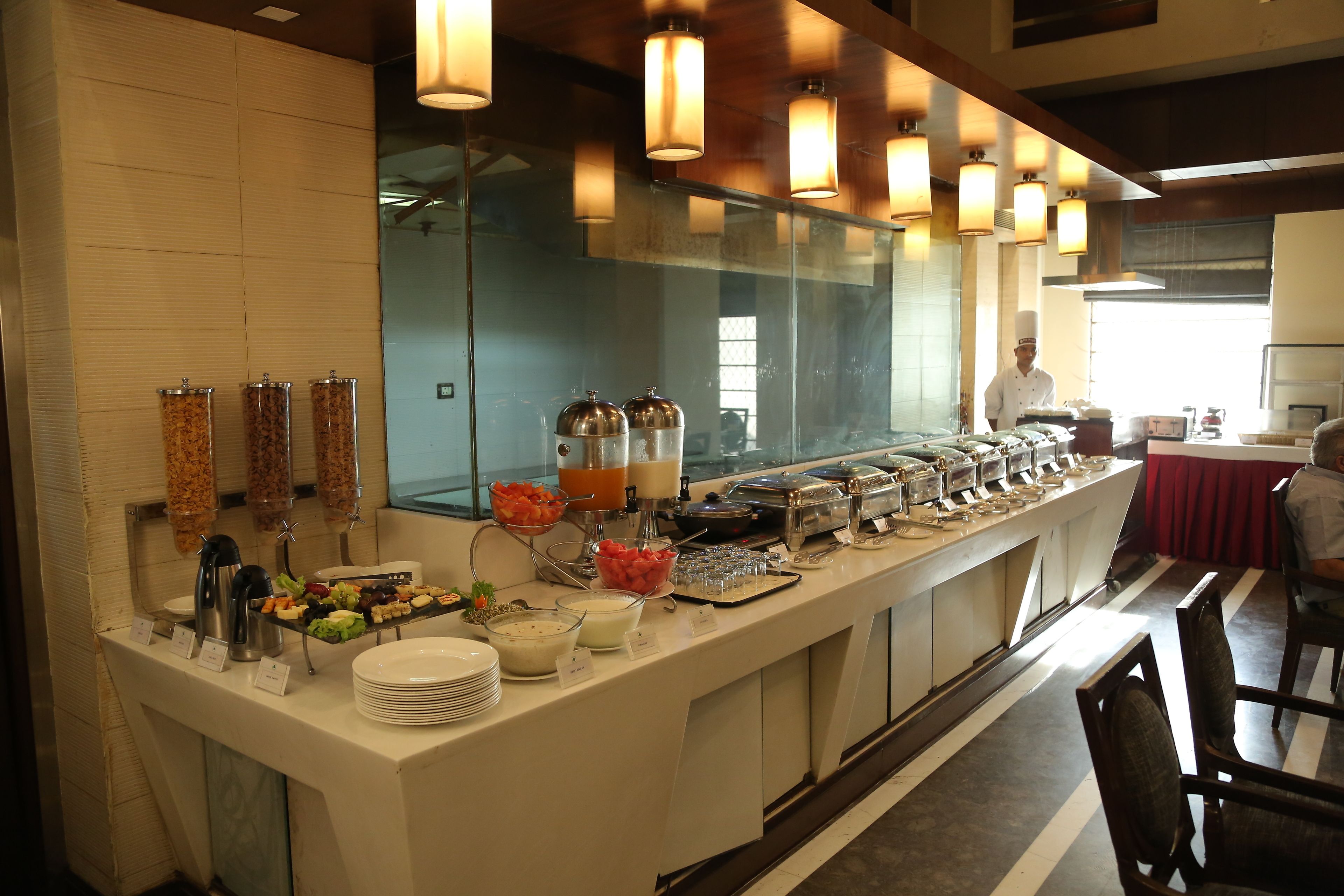 Disposição de buffet com diversos alimentos e bebidas.