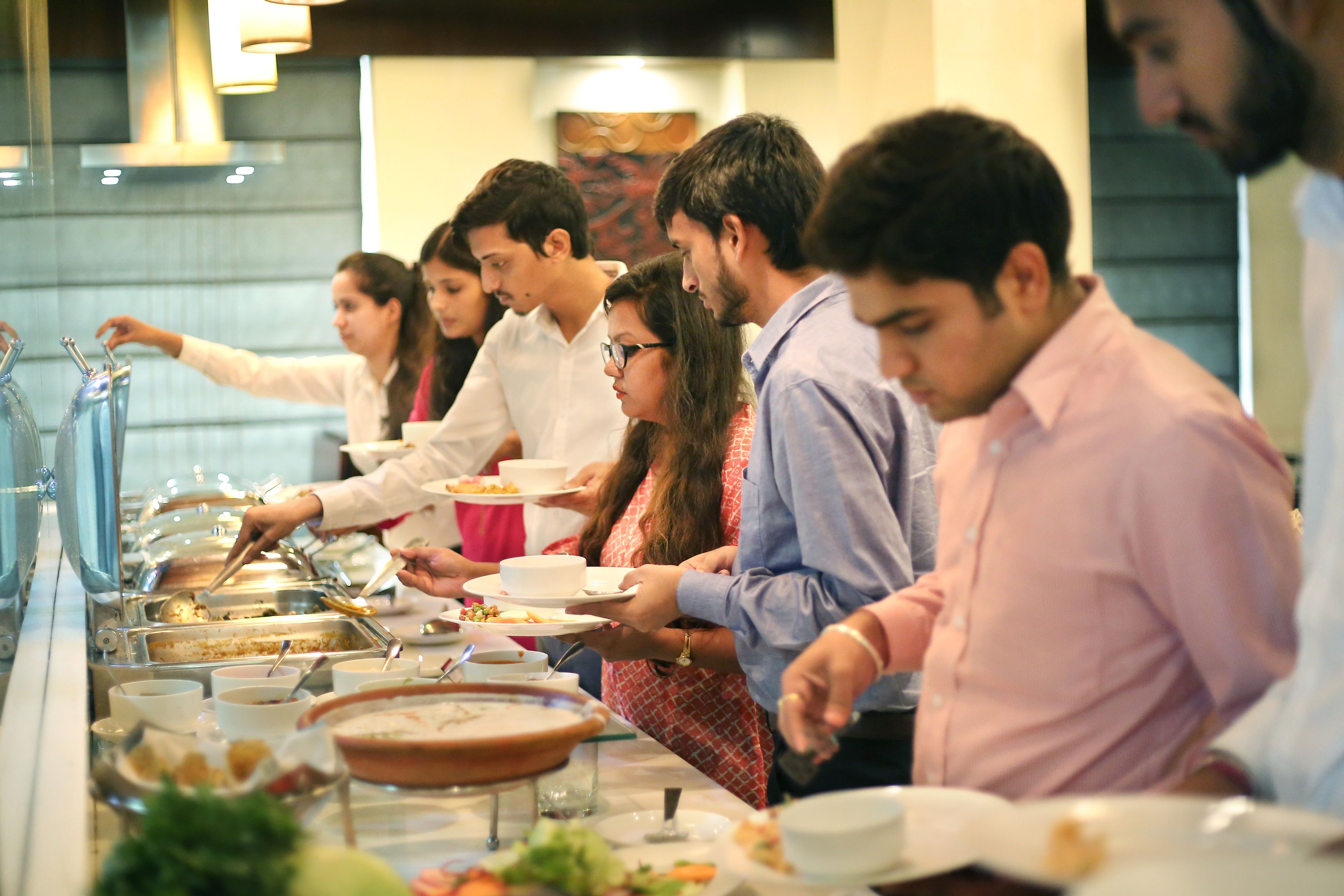 Una barra de buffet con diferentes platos y utensilios.