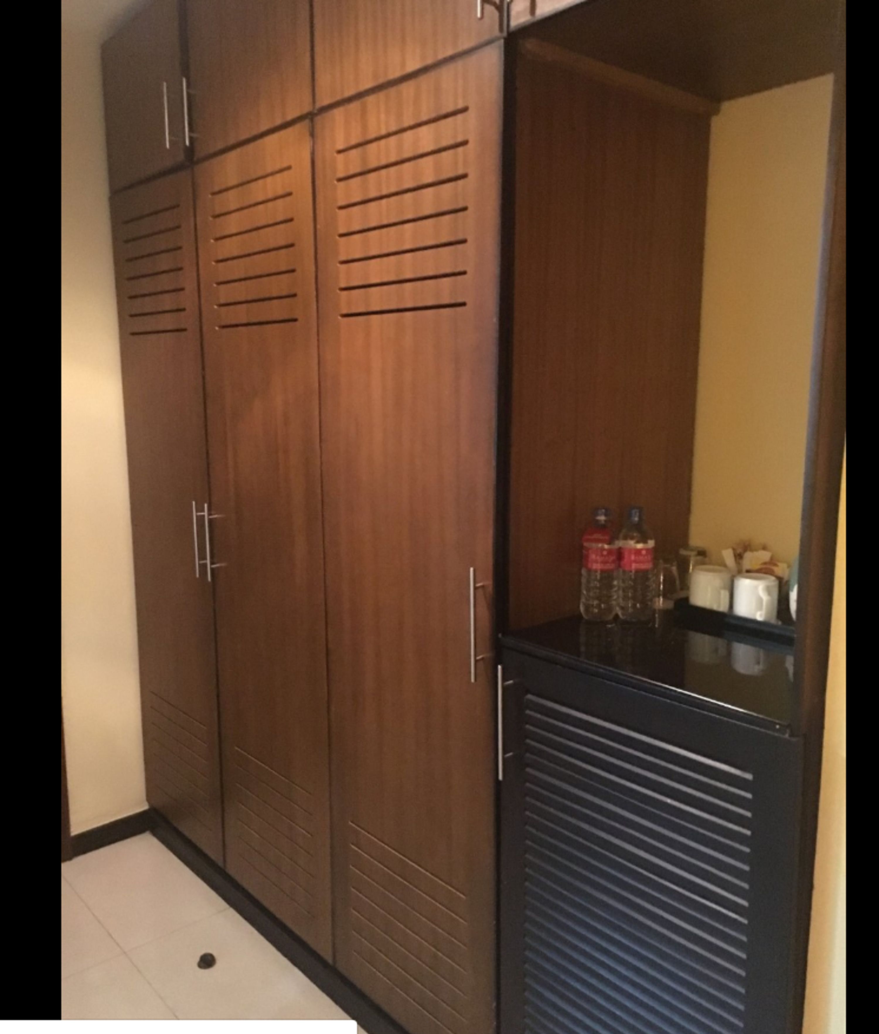 Ein Kleiderschrank mit horizontalen Lamellen und einem kleinen Spiegel.