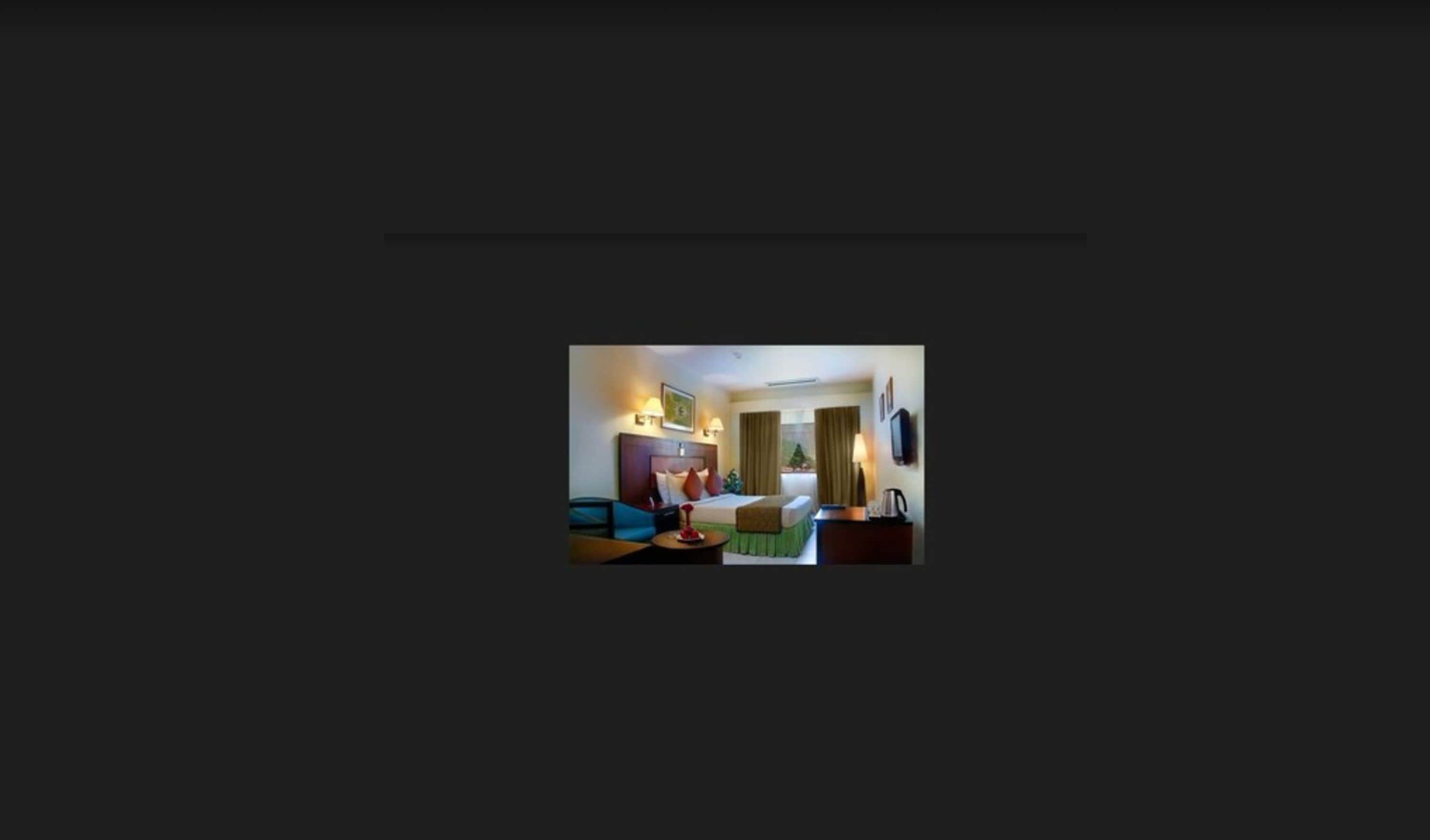 Een hotelkamer met een bed, bureau, stoel, bijzettafeltje en televisie.