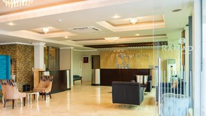 A modern lobby with a reception desk, seating area, and a stone accent wall. - Ramada by Wyndham Katunayake Colombo International Airport (Seeduwa - Katunayake)