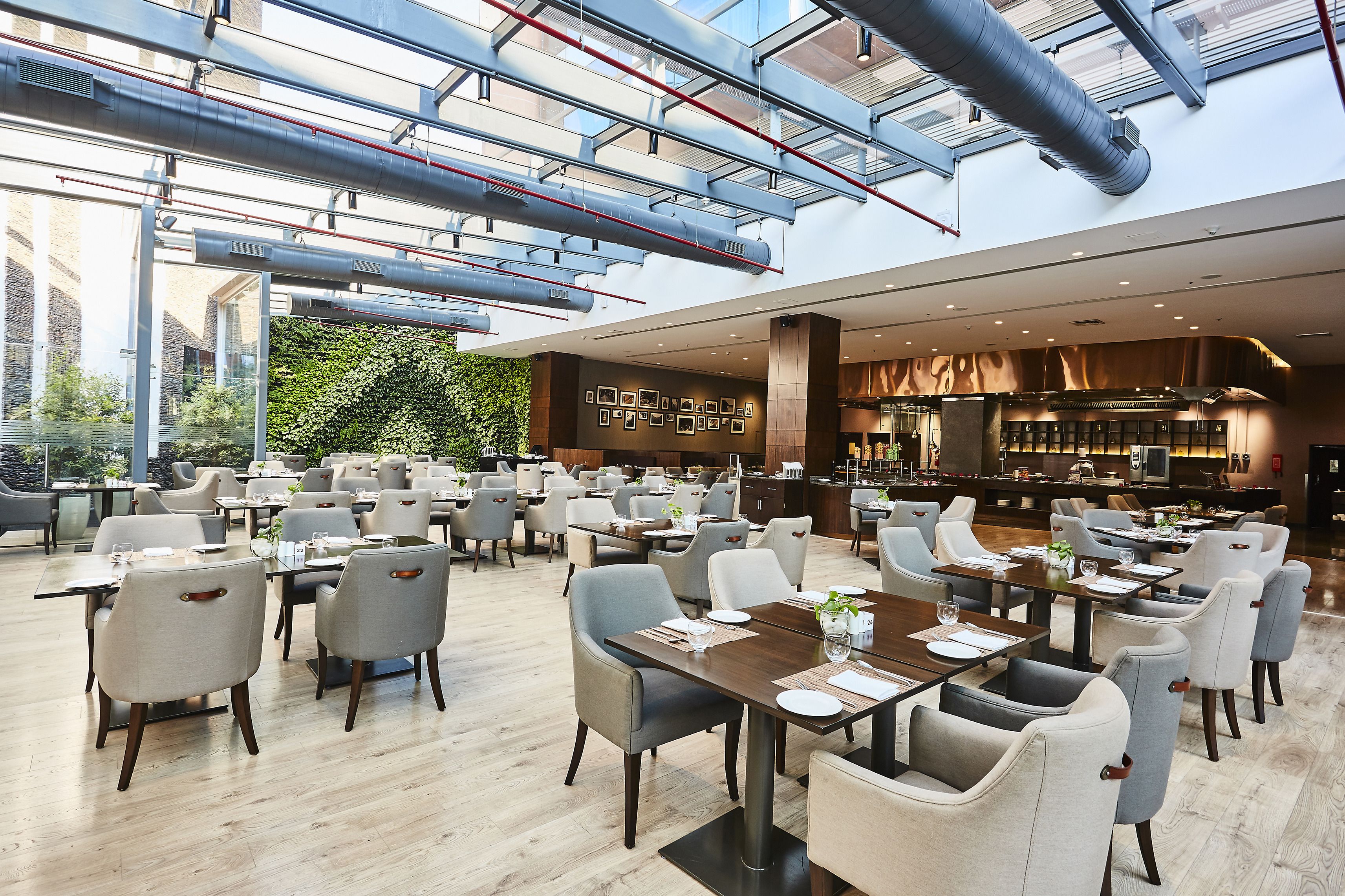 A spacious restaurant with high ceilings, exposed ductwork, and a modern interior design.