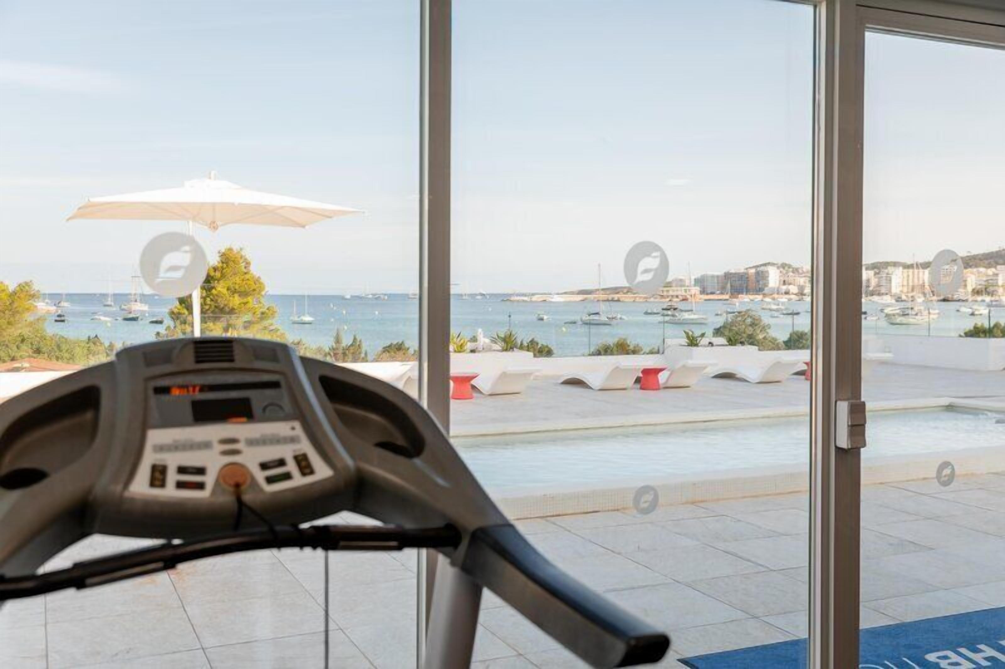 Ein Laufband mit Blick auf einen Yachthafen und Gebäude im Hintergrund.