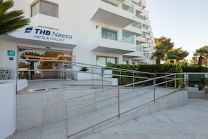 Ein THB Naeco Hotel & Chillout mit modernem Design, einer Treppe, die zum Eingang führt, und einem gepflegten Außenbereich.