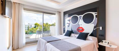 Une chambre d’hôtel moderne avec deux lits, une grande fenêtre offrant une belle vue, un téléviseur fixé au mur et une petite table avec un téléphone.