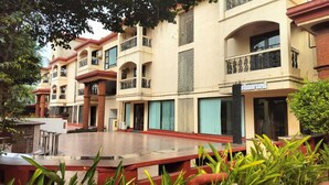 Pátio de hotel com várias varandas, um restaurante e um espaço central com assentos.