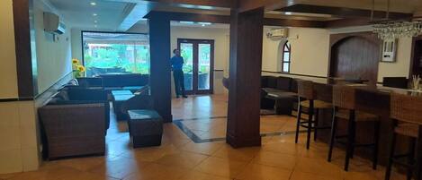 A lobby with a reception desk, seating area, and a view of the outdoors.