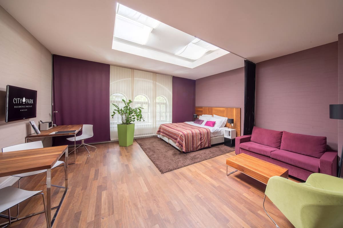 Une chambre d’hôtel moderne équipée d’un lit, d’un canapé, d’un bureau et d’une télévision.