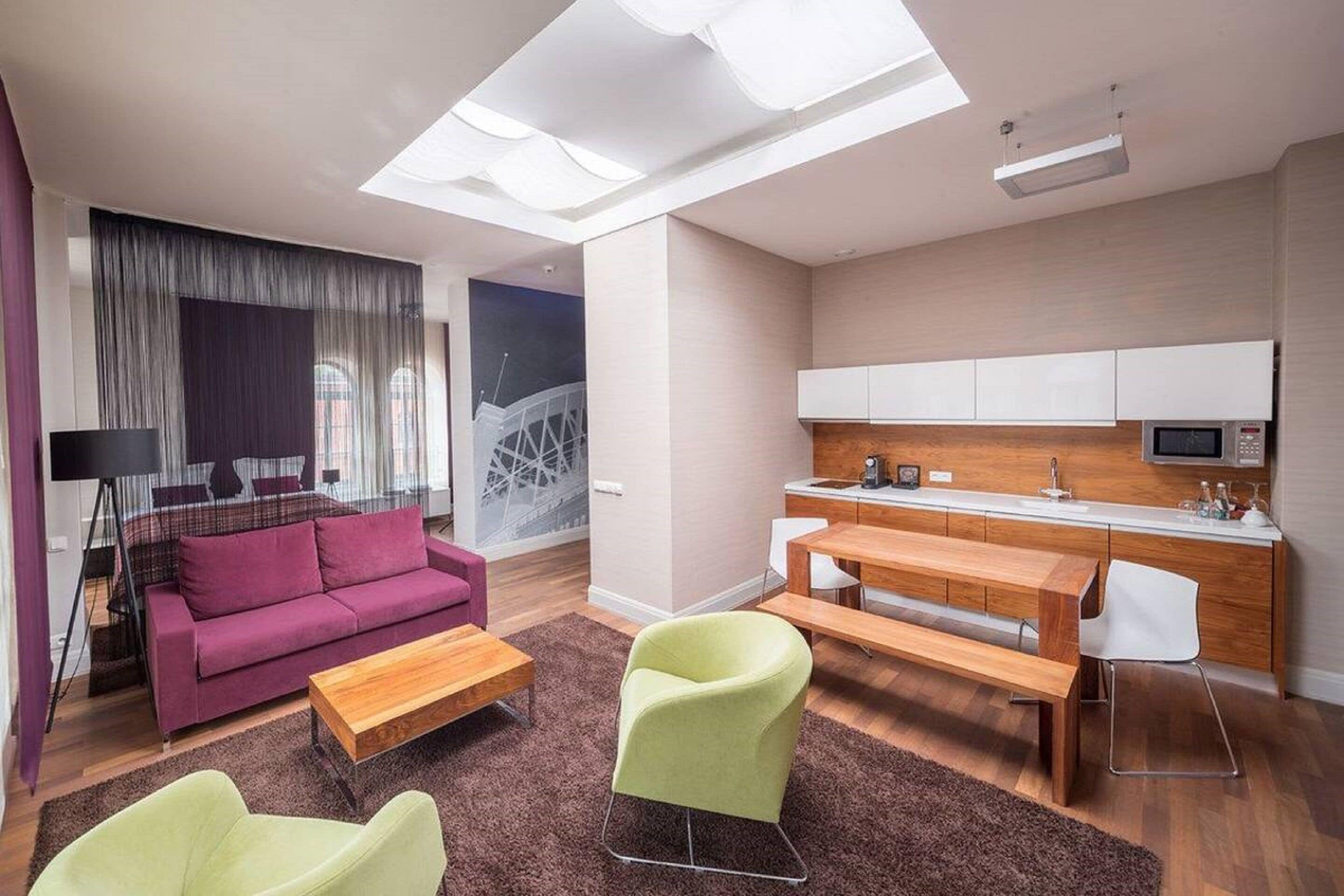 Eine moderne Wohnung mit Wohnbereich, Esstisch und Küche.