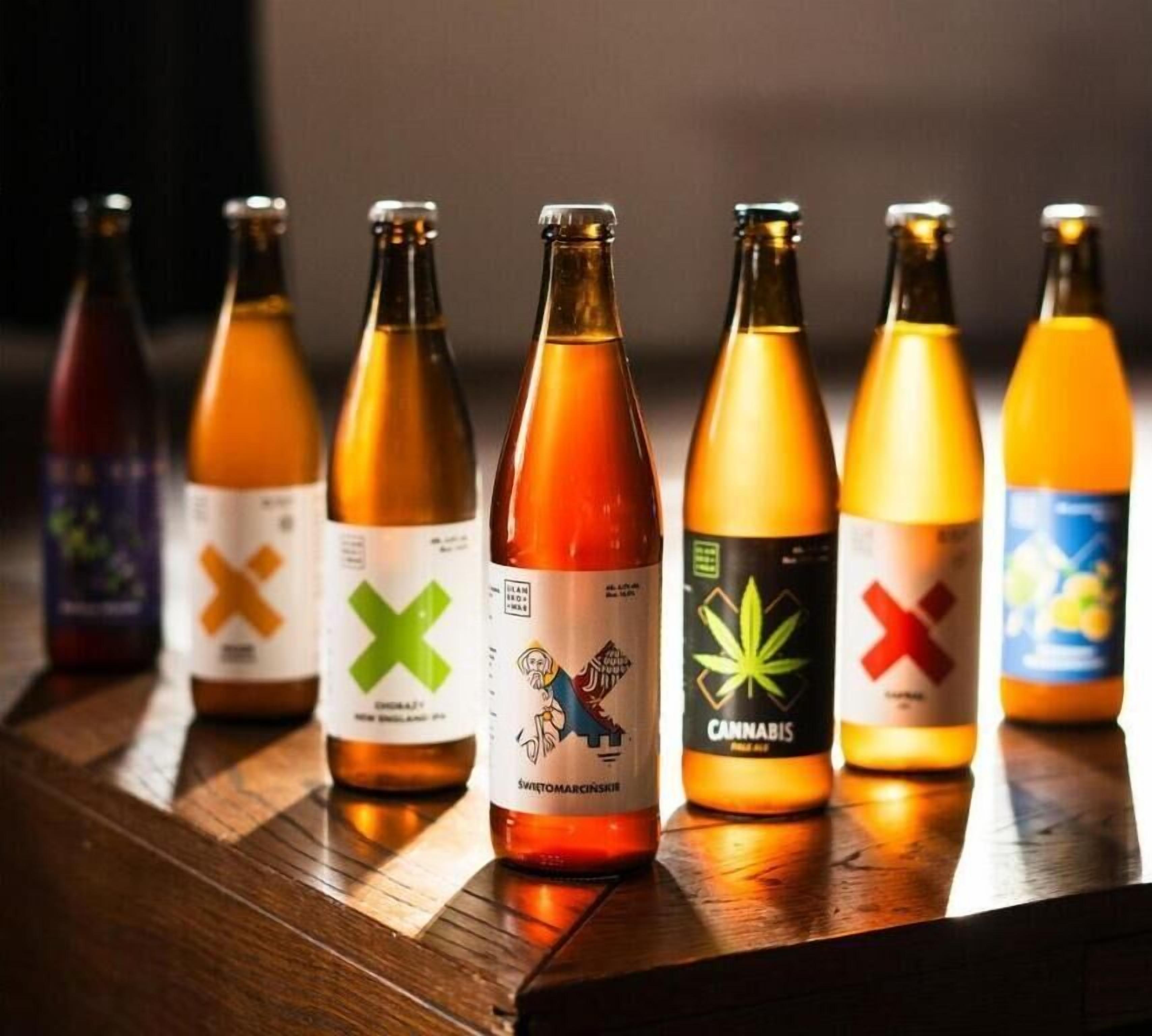 A row of bottles with various labels on a wooden surface.