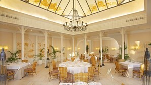 Un espace de restauration luxueux, avec des tables rondes, des chaises en osier et un plafond haut orné de motifs floraux.