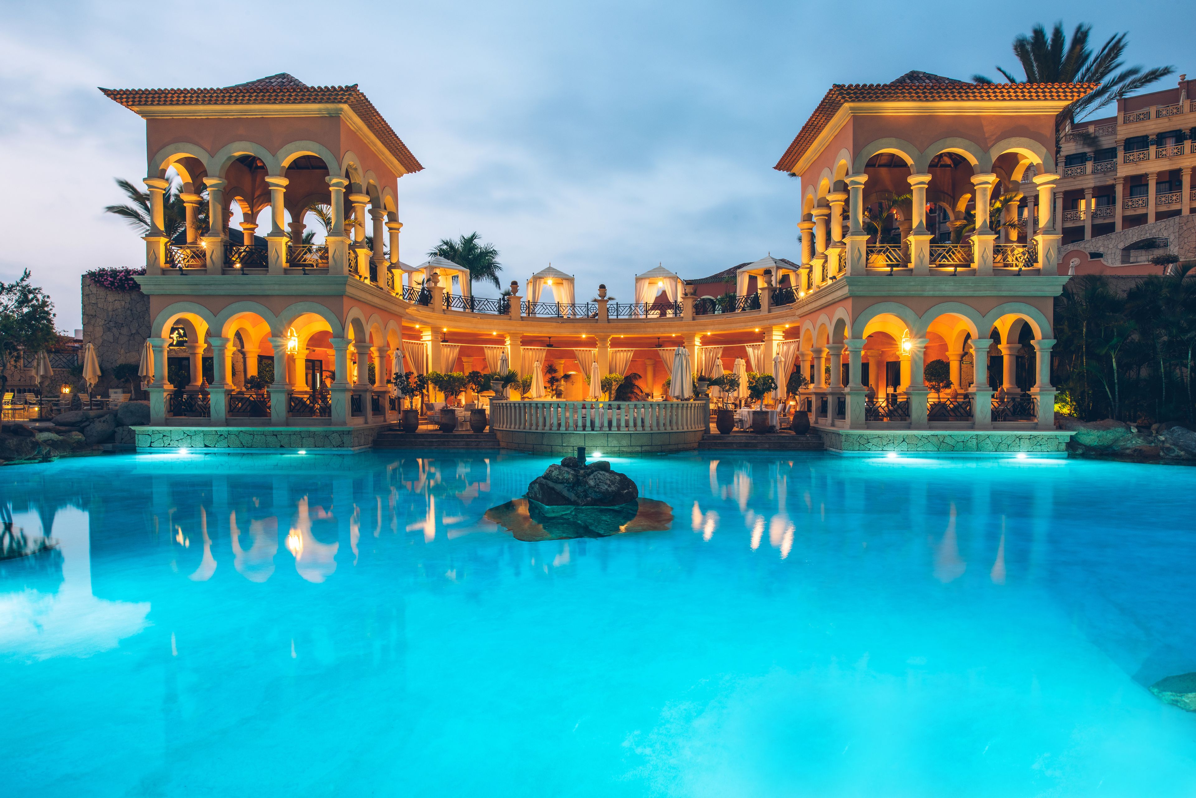 Un hotel grande e lussuoso con numerosi balconi e un cortile interno.